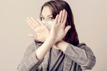 Woman portrait with medical mask she crossed her hands.Health And Medicine Concept. Covid19, Virus, Social Distancing And Quarantine. Focus on hands.