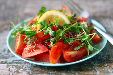 Selective focus. Healthy salad on a plate. Salad with tomatoes and micro-greens. Fitness diet. Quarantined food. Cooking at home.