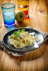 ravioli stuffed with parmesan cheese and garnished with mint leaves - italian food - closeup