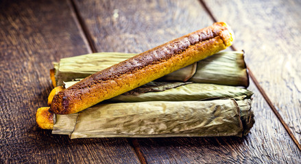 Broa made with corn and wrapped in banana leaf. Rural Brazilian dessert made in the states of São Paulo and Minas Gerais, known as Brazilian bread-a-pique, bread or Brazilian corn bread.