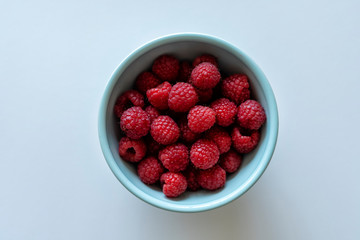 Fresh raspberries in a blue bowl