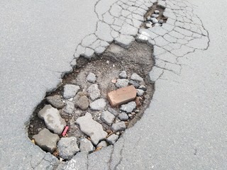 Old asphalt paving deterioration . Pothole  on the road. 