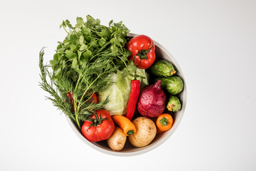 Vegetables in a round bowl on a white background. The view from the top