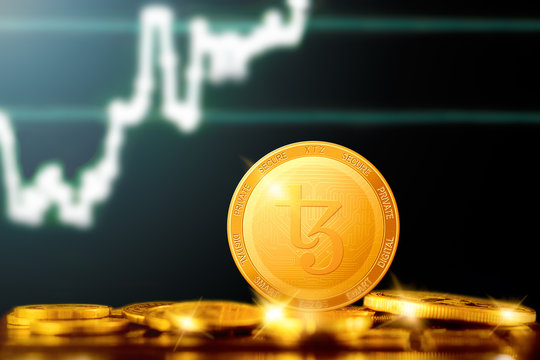 TEZOS (XTZ) cryptocurrency; TEZOS golden coin on the background of the chart
