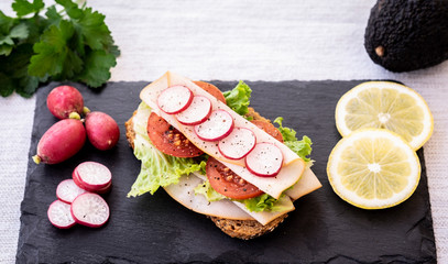 Tasty wholemeal sandwich with roasted turkey with lettuce, tomato and radishes. Ideal for a snack or a light and dietetic lunch