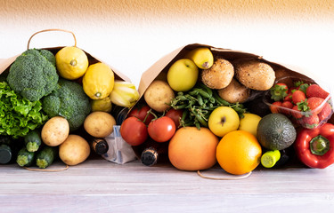 Paper shopping bags with food and drink for delivery home to people in quarantine for coronavirus Covid-19. Fresh food and stay home concept