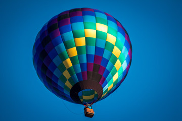 Hot air balloon flying by in a clear blue sky in Michigan
