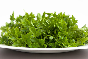 Parsley on a white plate. Useful plant. Dietary food. Vitamins. 