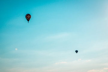 Hot air balloons rising on the horizon at sunset at an airshow in Battle Creek Michigan
