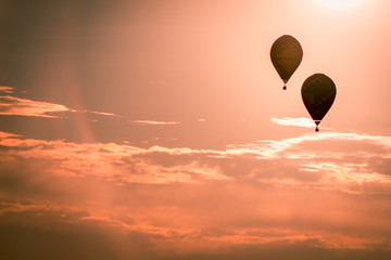 Hot air balloons soaring through the air at sunset at an air show