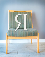 Letter I on the chair. In room. Selfishness illustration