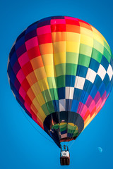 Rainbow hot air balloon flying through the sky at an air show in Battle Creek Michigan