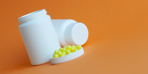 I poured the pills out of the bottle on an orange background. Concept of health, protection from viruses, flu and colds.