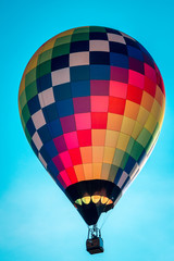 Rainbow hot air balloon flying through the sky in Michigan