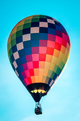 Rainbow hot air balloon flying through the sky