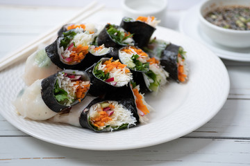 Vietnamese vegan rice paper and nori sheet spring rolls on white plate