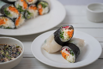 Vietnamese vegan rice paper and nori sheet spring rolls on white plate