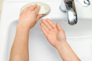 A Hands with soap are washed under the tap with water. Clean from infection and dirt and virus. At...