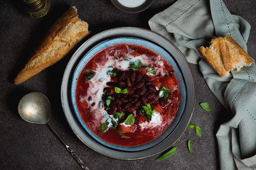 Traditional Ukrainian soup borscht with red beans and sour cream. Top view