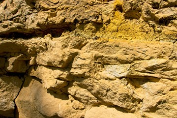 Stone texture and background. Rocky texture. Enormous face Aging and Divided by Huge Cracks and Layers. Thick, Rough Stone Texture Or Mountain Rock, Background And Thematic Geology And Mountain
