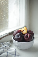 on a light background a plate with a plum
