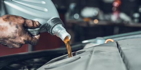 pouring new oil into the car engine from the canister during replacement