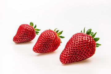 Group of three strawberries isolated on white background