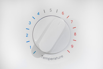 Thermostat with nine levels of temperature regulation, blue cold zone and red hot, white dial on 6 position, isolated on white background.