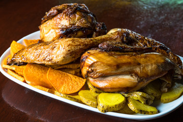 fried chicken fillets garnished with potatoes and sweet potatoes. Selective focus. Peruvian grilled chicken