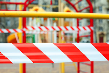 Warning tape close up on closed playground. Quarantine Covid-19.