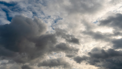 A cluster of light and fluffy clouds interspersed with dark gray clouds. Before the rain and the thunderstorm.