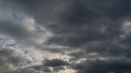 Fototapeta premium A cluster of light and fluffy clouds interspersed with dark gray clouds. Before the rain and the thunderstorm.