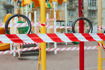 Fitness equipment and playground closed for quarantine Covid-19. Playground is blocked by red warning tape