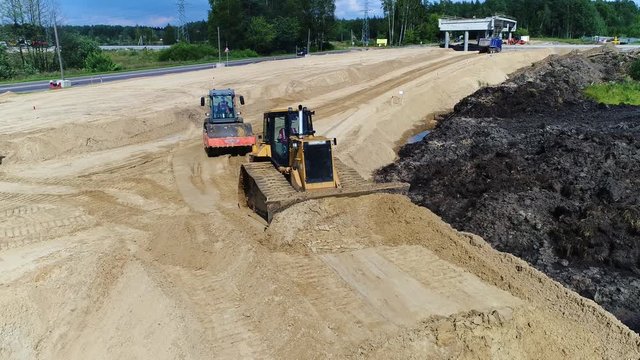Bulldozer and roll leveled sand. New road construction transport infrastructure