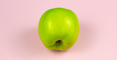 Green apple isolated on a pink background.