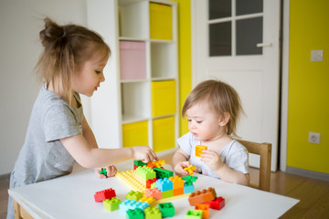 Naklejka premium kids play in the constructor. small child builds a castle out of blocks. concept of development of fine motor skills