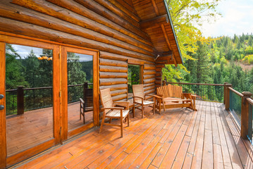 Private rustic log home with a large wood plank deck in the North Idaho mountains in a very peaceful setting - obrazy, fototapety, plakaty