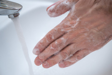 Fototapeta premium Washing hands rubbing with soap man for winter flu virus prevention, hygiene to stop spreading germs.