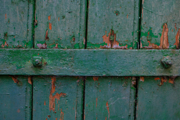 Wooden surface painted in green color. With a cross iron bar. Empty frame worn and damaged.