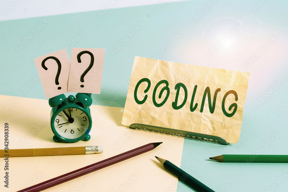 Poster Word writing text Coding. Business photo showcasing assigning code to something for classification identification Mini size alarm clock beside stationary placed tilted on pastel backdrop