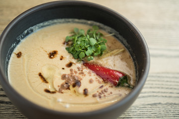 Vegetable cream soup with a whole red chili pepper