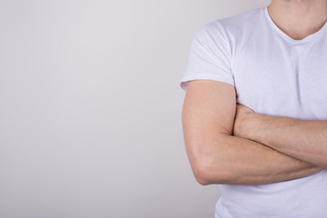 Cropped close up photo portrait of professional entrepreneur student wearing white simple t-shirt standing with crossed arms isolated gray color background