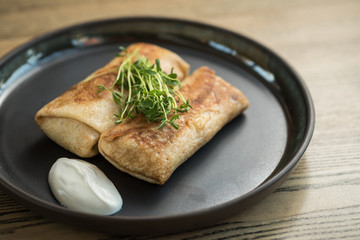 Filled pancakes with sour cream