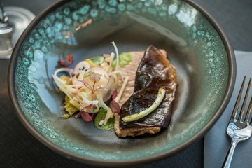 Cooked salmon fillet with root salads and onions
