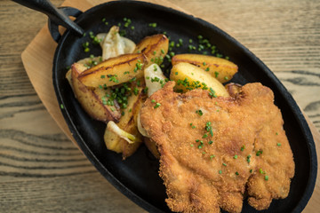 Breaded pork meat with fried potatoes