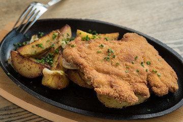 Breaded pork meat with fried potatoes