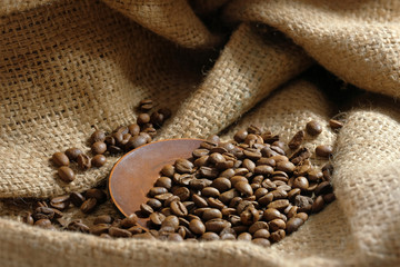 Coffee roasted beans on burlap, closeup. Coffee background.