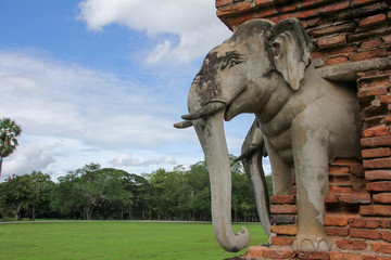 Naklejka premium Stone elephant in Sukhothai with vegetation in the background