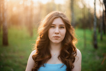 Naklejka premium Beautiful young girl in a blue dress in a spring park