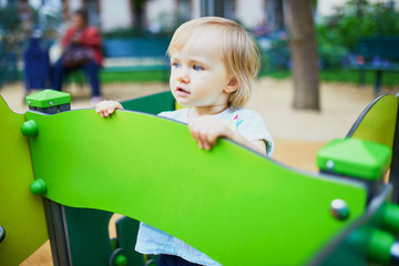 Adorable toddler feeling sad on playground